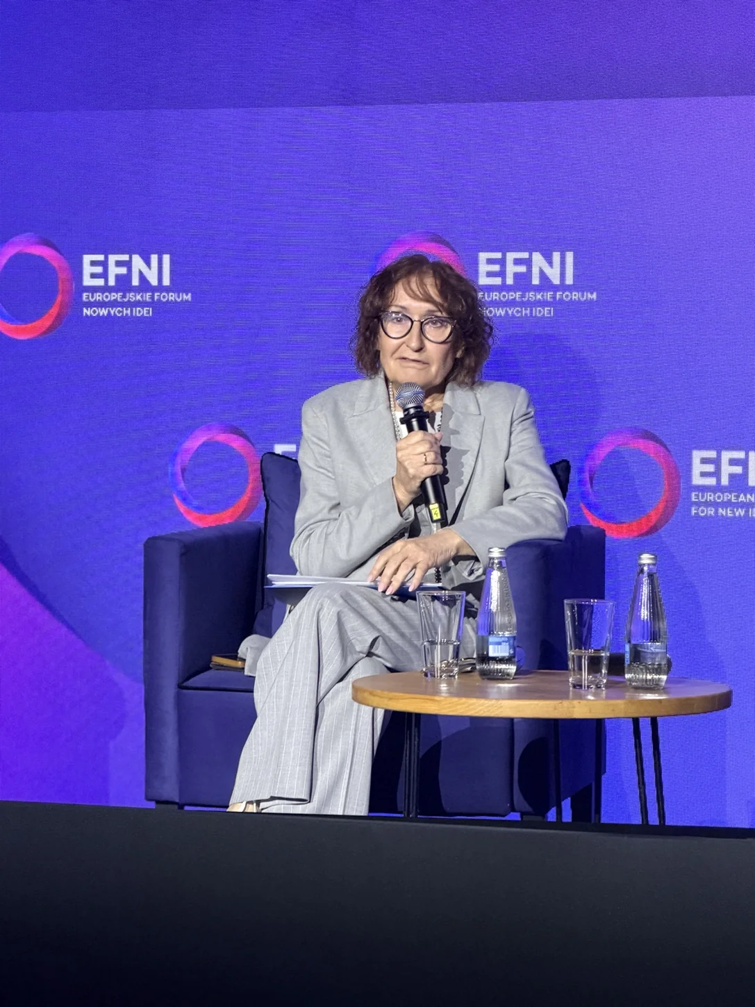 Uczestniczka panelu o zdrowiu na EFNI z mikrofonem i notatkami